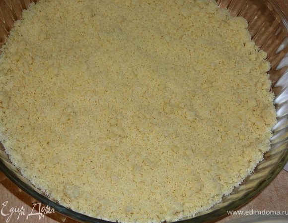 Крошку разделить на две части.Первую по-больше,вторую чуть меньше.В форму 26см.Высыпать большую половину крошки,разровнять.