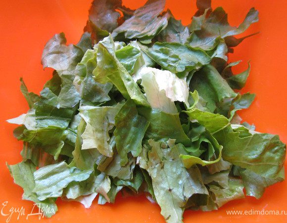 Листья салата Ромэн тщательно промыть и просушить. Затем листья салата Ромэн порвать руками на небольшие фрагменты удалив сердцевины листьев.