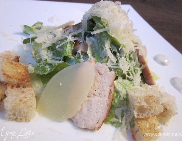 Листья салата Ромэн заправить соусом, добавить гренки, натертый сыр Пармезан. Аккуратно перемешать и выложить на тарелку. Украсить обжаренными кусочками куриной грудки, ломтиками сыра Пармезан и гренками. Приятного аппетита!