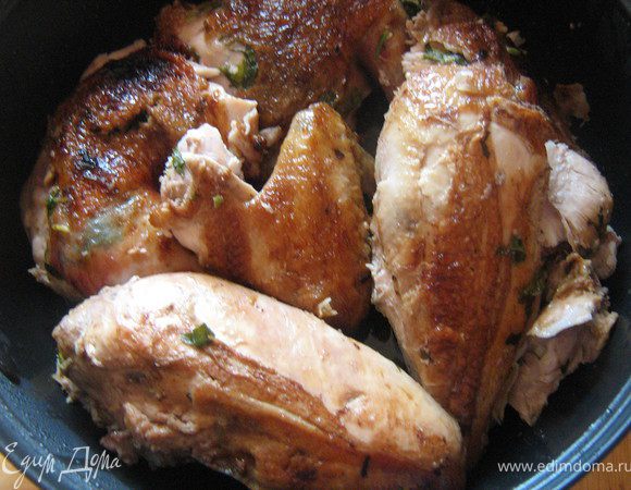 Курицу разрезать по грудке. 

Смешать вместе сливочное масло, зелёный лук, чеснок, петрушку,цедру, соль и перец. Аккуратно распределить смесь под куриной кожей по всей курице.

 Нагреть оливковое масло на сковороде, положить курицу и обжарить до золотистого цвета, около 3-х минут с каждой стороны Обжаренную курицу переложить на противень.

 Смешать вместе уксус, сахар и клюквенный сок в небольшой кастрюльке. Поставить на средний огонь и довести до кипения. Убавить огонь и готовить глазурь еще 15 минут, до состояния сиропа.

 Духовку нагреть до 200 градусов. Смазать курицу растопленным сливочным маслом и запекать 10 минут. Затем смазать глазурью и запекать еще 20-25 минут.

 Готовую курицу порезать на порционные куски.