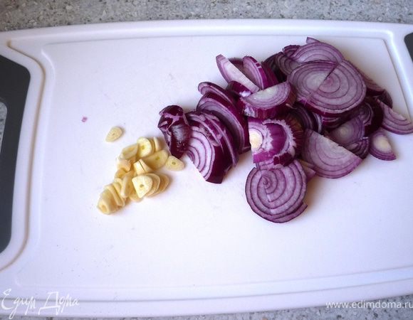 Лук почистить и нарезать полукольцами. Чеснок нарезать колечками.