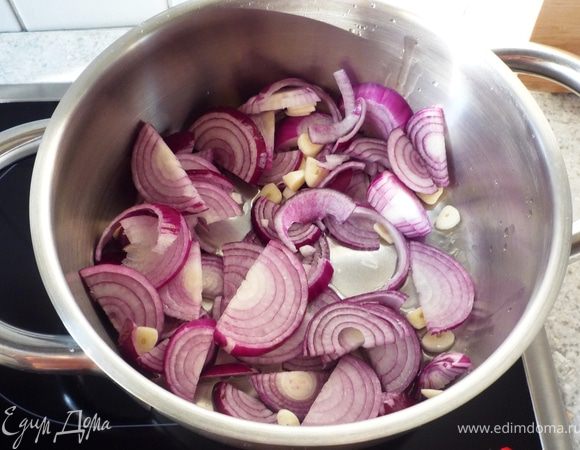 В неглубокой кастрюле разогреть масло и обжарить лук с чесноком.