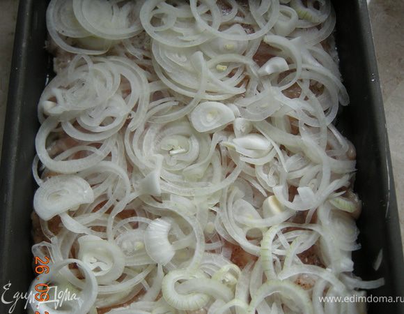 Лук нарезать на кольца и уложить поверх курицы. 