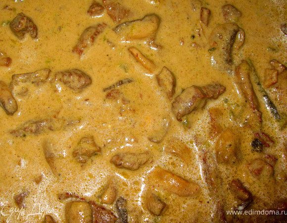 Переложить грибы к мясу, добавить корнишоны. Перемешать и влить сливки. Поставить сотейник на медленный огонь и томить под крышкой примерно 1 час, периодически помешивая. Затем снять с огня, дать минут пять остыть без крышки и вмешать сметану. Наш бефстроганов готов.