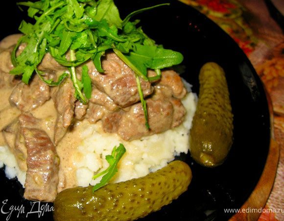 Первый вариант подачи это выложить бефстроганов поверх картофельного пюре, размятого с репчатым луком и чесноком. Сверху посыпать зеленью петрушки, кинзы или рукколы. можно дополнить блюдо хрустящими корнишонами.