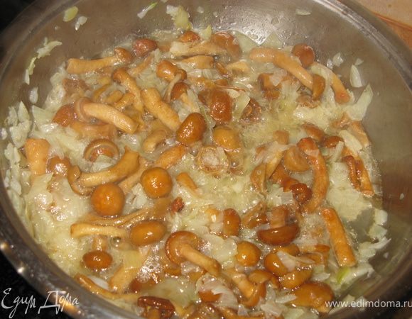 Лук мелко режем и обжариваем на масле до золотистого цвета. Добавляем к луку оставшиеся грибы, обжариваем. Тягучий сок, который выделяют опята при жарке, хорошо карамелизует лук.