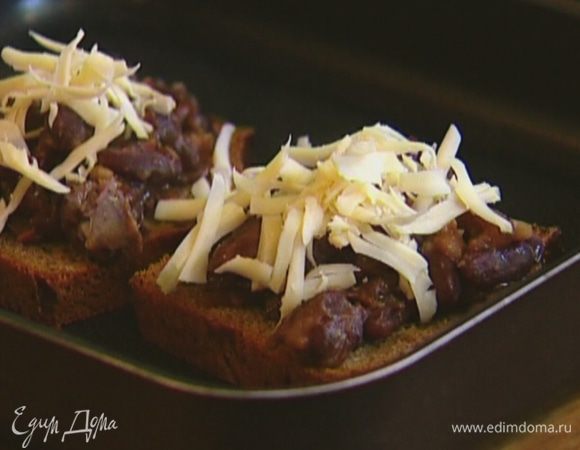 На противень поместить хлеб, выложить на него фасолевую начинку, посыпать натертым сыром и отправить под гриль на 2−3 минуты.