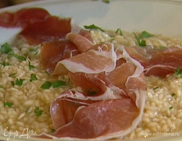 Разложить ризотто в тарелки, посыпать петрушкой, сверху выложить ломтики ветчины и хлопья пармезана.