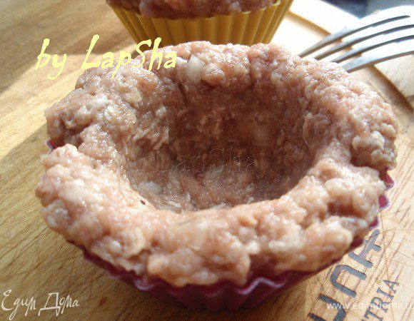 Формочки для кексов смазать растительным или оливковым маслом. Выложить в них фарш, формируя корзиночки. 