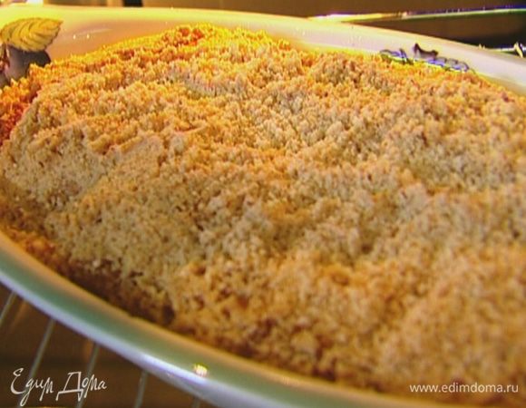 Посыпать пирог ореховой крошкой и отправить в разогретую духовку на 45−50 минут.