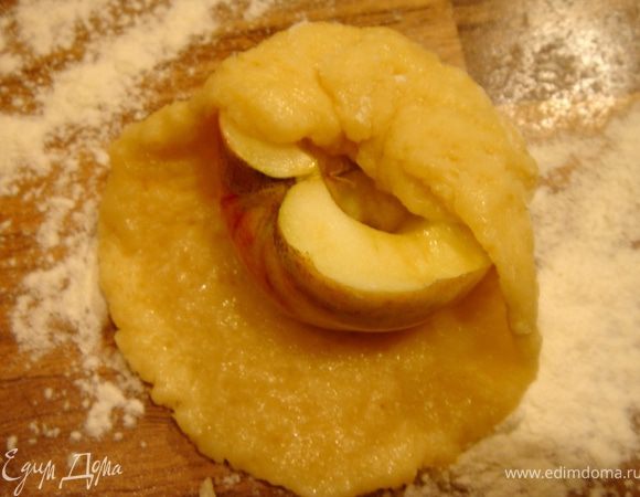 Тесто разделить на 12 частей(если фрукты крупные,то разделите тесто на своё усмотрение). Раскатайте каждую часть в лепёшку,сверху положите половинку яблока,срезом вверх.В выемку в яблоке можно разместить орех.Соберите края лепёшки вокруг яблока. 