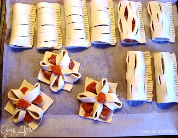 Противень застелить пекарской бумагой и разложить слоечки.