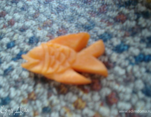 Вырезаем чешуйки, для этого прорезаем полукруги, а затем вырезаем из под них мякоть. Таким же образом вырезаем полоски на плавниках и хвосте.