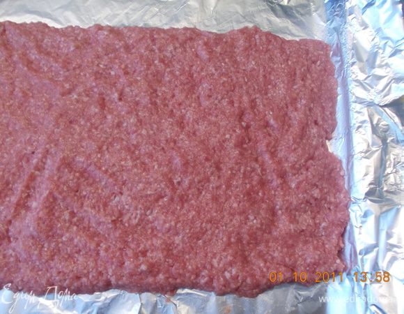 На противень стелим фольгу и ровным слоем распределяем по ней фарш