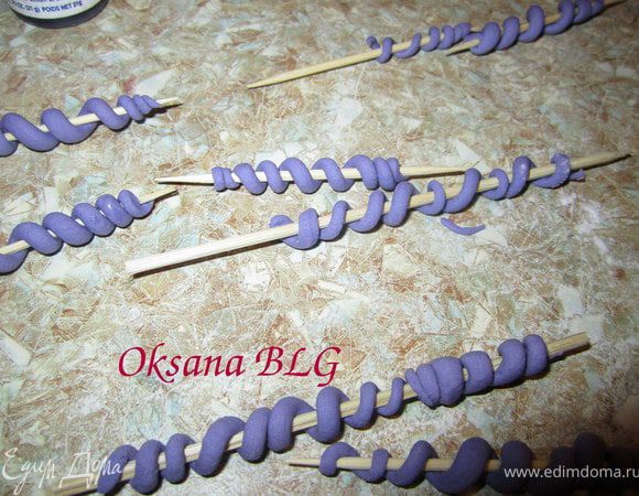 Из фиолетовой мастики накатать тоненькие жгутики и закрутить их на зубочистки. Оставить сохнуть.