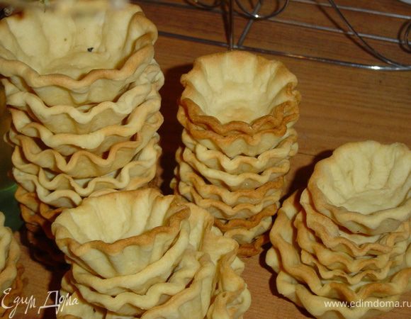 Начинаем приготовление закуски с изготовления корзиночек. Для этого надо в молоке растворить сахар, соль, часть муки и желток, хорошо перемешать.
Размягченный маргарин взбить, соединить с приготовленной массой и остатком муки. Раскатываем тесто и вырезаем кружки по размеру формочек. Выкладываем кружочки в формы, смазанные маргарином, дно прокалываем.
Выпекаем при температуре 240*С до золотистого цвета. Когда корзинки готовы, приступаем к начинке.
Берем огурцы и с помощью волнистого ножа нарезаем небольшими кусочками.Так же поступаем с помидором и сладким перцем. Овощи нарезаны и мы приступаем к приготовлению соуса.
Для этого смешиваем оливковое масло, винный уксус, молотую паприку, лук-пудру, сушеную кинзу, душистый и черный перец и немного соли. Измельчаем чеснок, натираем сыр и добавляем все это к приготовленной смеси. Тщательно перемешиваем. А теперь наполняем корзиночки. Первым слоем выкладываем огурцы, а на них соус. Второй слой - перец, и соус.Третий слой - помидоры.Сверху помидоров выкладываем немного соуса и украшаем веточкой петрушки.
  Закуска готова!  Приятного аппетита!