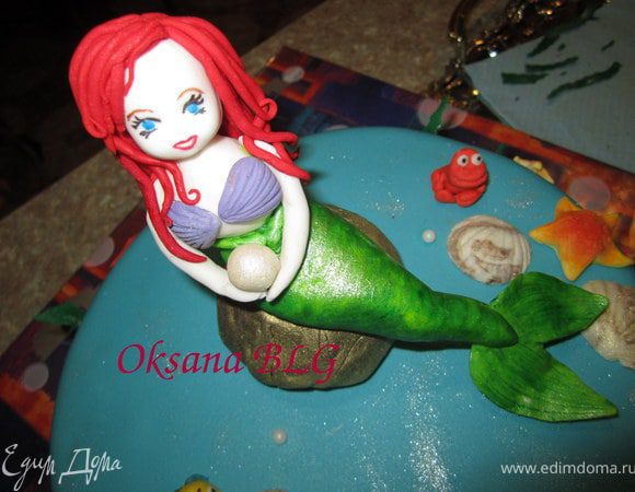 Закрепить "камень" на торте, усадить русалочку ( ее лучше закрепить на зубочистку, что бы уж наверняка.)) что бы она случайно не уплыла.)))