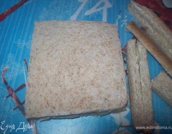 Накрыть хлеб с огурцом вторым ломтиком маслом вниз и срезать корки