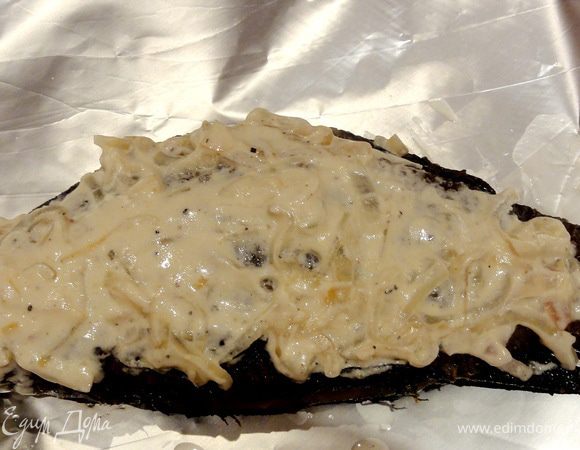Выкладываем рыбу на фольгу, поливаем сметанным соусом с луком. 