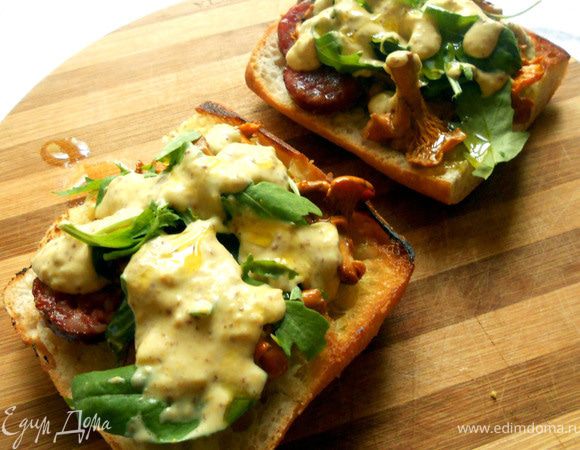 Чиабату нарезать поперек, сбрынуть оливковым маслом, подсушить на сухой сковороде, с двух сторон. На одну половину выложить колбасу, лисички, руколу, немного соуса, сбрызнуть маслом. Накрыть второй половиной и подавать! 