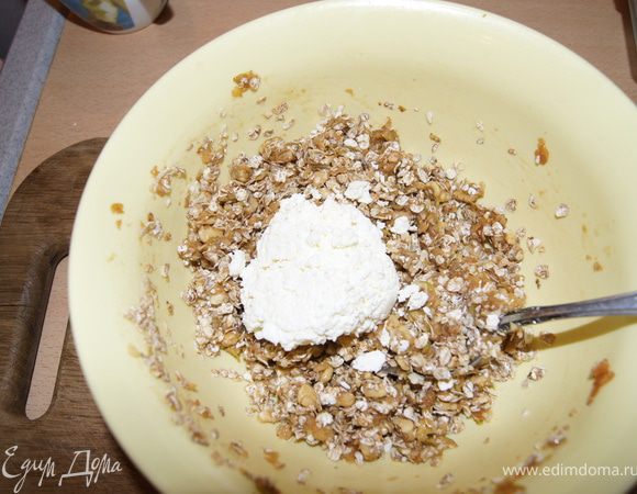 Добавить сахар, оливковое масло, орехи, муку, овсяные хлопья Нордик, творог и молоко. Хорошо перемешать.