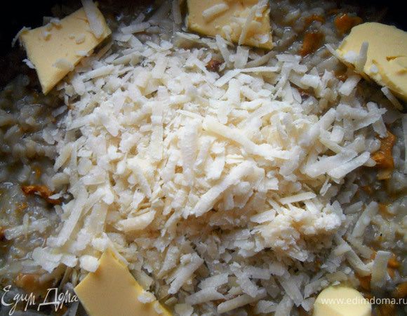 Огонь выключить (рис должен быть al-dente и вообще без фанатизма - слишком жесткий или мягкий не годится!). Добавить сливочное масло и пармезан, накрыть крышкой и дать постоять несколько минут, после чего хорошо размешать (практически взбить!) вилкой или ложкой. Подавать, украсив целыми лисичками и присыпав небольшим количеством пармезана. 