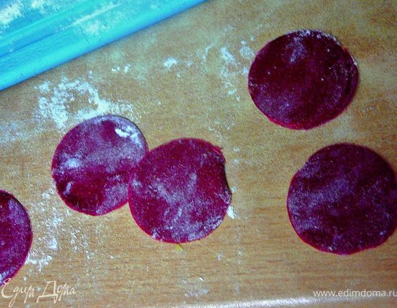 Через час достать тесто и на присыпанной мукой рабочей поверхности раскатать тесто.Вырезать кружочки с помощью маленького стаканчика(рюмочки).