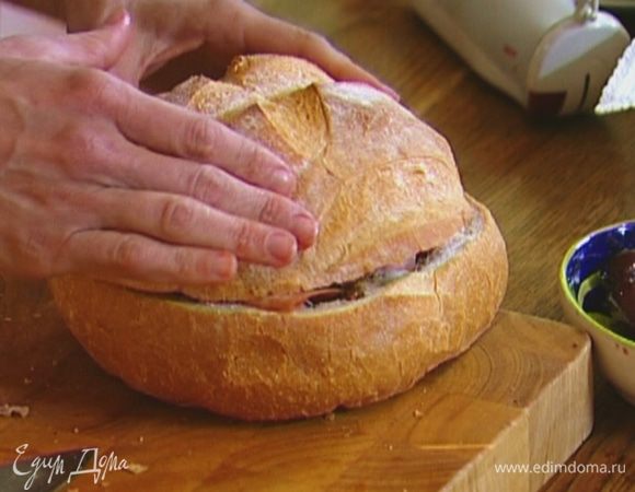 Положить внутрь нижней половины батона три куска колбасы, три куска салями, три куска сыра, затем снова по три ломтика салями и вареной колбасы; накрыть все верхней половиной хлеба и придавить так, чтобы «крышка» коснулась начинки.