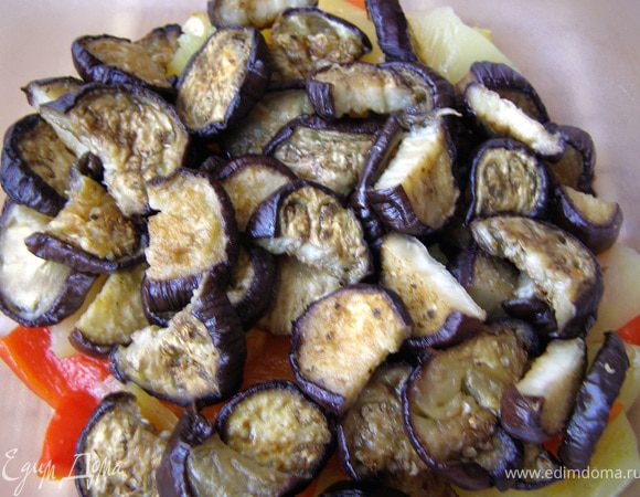 Отжать жидкость с баклажанов, обсушить бумажным полотенцем. Накрытый фольгой лист смазать 1 ст.л. масла, выложить баклажаны, сверху смазать маслом при помощи кисточки, посыпать травами и запекать в прогретой до 200 гр. духовке 15 мин с одной стороны и 10 мин с другой, снизив температуру до 180 гр. Выключить духовку и оставить баклажаны в ней ещё на 5 мин. Крупные кружки порезать пополам. мелкие оставить как есть. Я стараюсь брать баклажаны длинные и тоненькие, там меньше семян в мякоти, да и кружки резать не нужно.