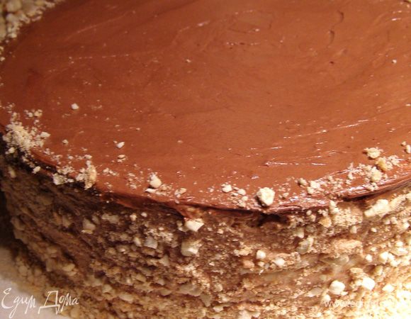 Украсим бока торта крошкой. Для этого смешаем крошки безе, тщательно собранные с коржей (у меня получилось 3 ст.л.) с таким же количеством толчёных орехов кешью. Приподнимая бока торта поочерёдно, посыпаем их ореховой смесью. Поставим торт на полчаса в холодильник, чтобы крем "схватился".