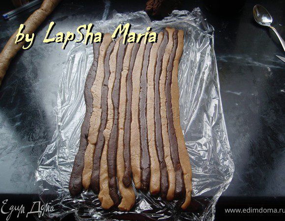 От светлого теста отрезать половину. Раскатать пласт примерно 28Х6 см. Нарезать на 6-7 полосок. Тоже самое проделать с шоколадным тестом. Затем на пищевой пленке поочередно выложить полоски. 