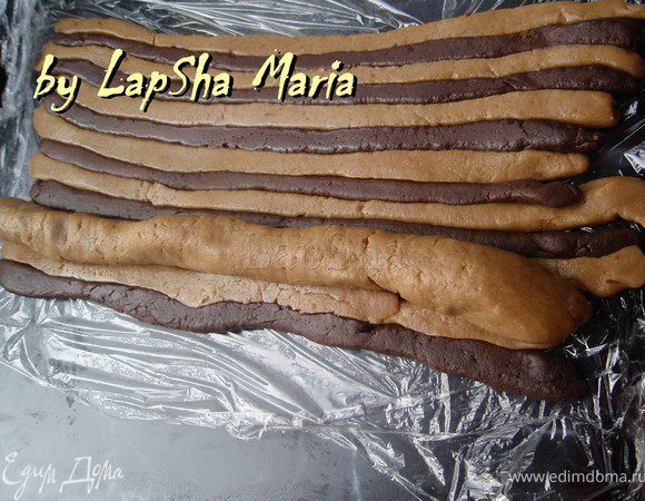 Из оставшейся половины светлого теста раскатать колбаску 28см в длину. Уложить ее на полосатый пласт теста.