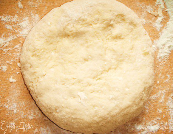 На посыпанный мукой стол выложить тесто, немного месить, пока не станет отходить от рук. 