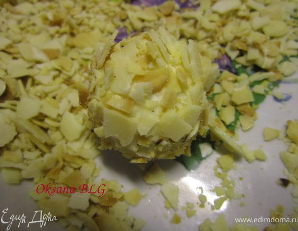 Половину шариков обвалять в растопленном белом шоколаде, затем в миндальных крошках.