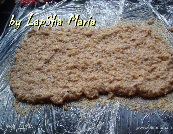 На столе выстелем пищевую пленку, у меня получилось два ряда внахлест. Присыпем панировочными сухарями. И аккуратно ложкой выложим гречневую массу, распределяя в пласт толщиной 1-1,5 см.