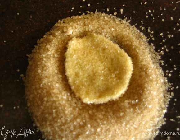 Насыпать на стол горку сахара(1/4 стакана.Шарик положить на сахарную горку и пальцами сформировать лепешечку, вдавливая в сахар, сначала с одной стороны, потом перевернуть на другую. Толщина 1,5-2мм в диаметре примерно 5-6см. По мере того как сахар заканчивается, подсыпать.
