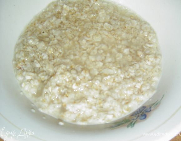 Первым делом размораживаем тесто, а в это время займемся приготовлением начинки. Размораживаем шпинат в микроволновке, а затем хорошенько отжимаем. Овсяные хлопья заливаем небольшим кол-вом воды или молока и даем постоять минут 10. К полученной овсянке добавляем шпинат, натертый на терке сыр, яйцо, солим и перчим по вкусу, тщательно перемешиваем.
 Размороженное тесто раскладываем на столе, притрушенном мукой, не раскатываем и каждый из пластов разрезаем на три части. Вдоль полосок выкладываем начинку равномерным слоем, затем защипываем тесто и получаем шесть "колбасок". Поверхность, на которой будем выпекать пирог застилаем пергаментной бумагой и выкладываем на нее, начиная с середины наши колбаски по спирали, соединяя их между собой. Верх пирога смазываем желтком и посыпаем кунжутом. 
 Выпекаем при температуре 180 гр. 25-30 минут.
 Приятного аппетита!!!