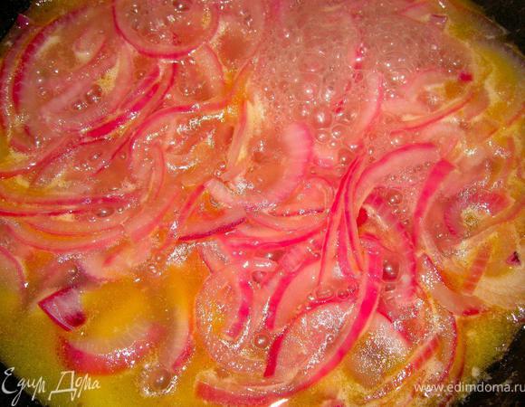 Самое время приготовить морского окуня. Для начала сделаем овощи. Красный лук нашинкуем тонкими полукольцами. Теперь в разогретый сотейник добавим половник овощного бульона и выложим лук, тушим пока лук не станет мягким, после чего добавим немного сливочного масла и убавим огонь.