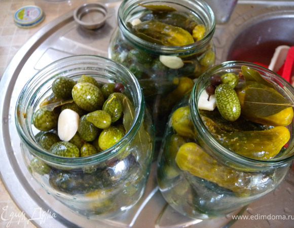 4. Вылить воду в кастрюльку. Промыть проточной водой огурцы (не доставая с банки). Воду прокипятить. Залить обратно в банки с огурцами и мелотирией. 