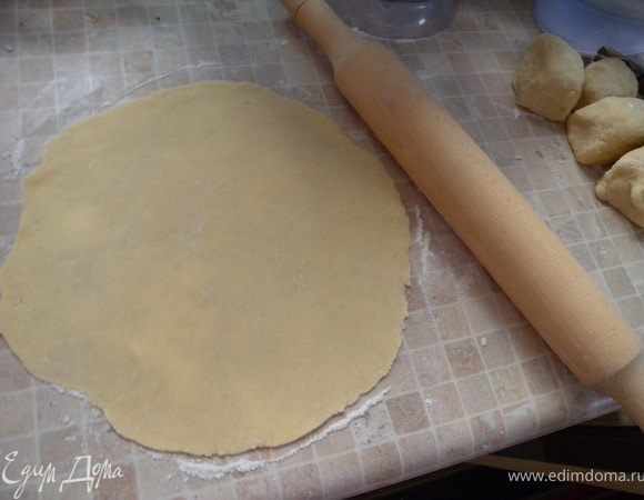 2. Разделить тесто пополам. Одну часть отставить, можно в холодильник. Вторую разделить натри. Раскатать одну (из трех) лепешку на посыпанной мукой столешнице. Наколоть вилкой, так как тесто надувается при выпечки в раза три...