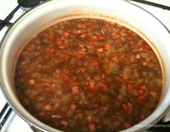 В кипящую воду выложить мясо-луково-огуречно-томатную смесь и уменьшить огонь. Посолить, добавить специи. Варить около 20 минут.
