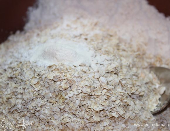 В отдельной миске смешиваем муку,хлопья и разрыхлитель.