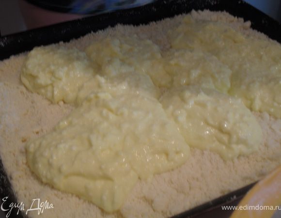 В прямоугольную форму,размером 20*30, выстеленную пергаментом уложить 2/3 сухой смеси, сверху распределить творожную массу, верх посыпать остатками сухой смеси.