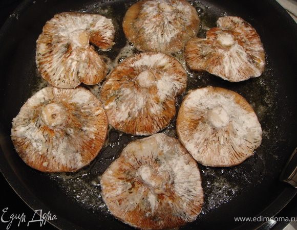 Посолить, присыпать небольшим количеством муки. Растопить в сковороде  сливочное масло. Начинать обжарку с внешней стороны шляпки. Жарить грибочки минут 5 на среднем огне. Перевернуть. Рыжики должны получиться золотистого цвета с хрустящей корочкой. 