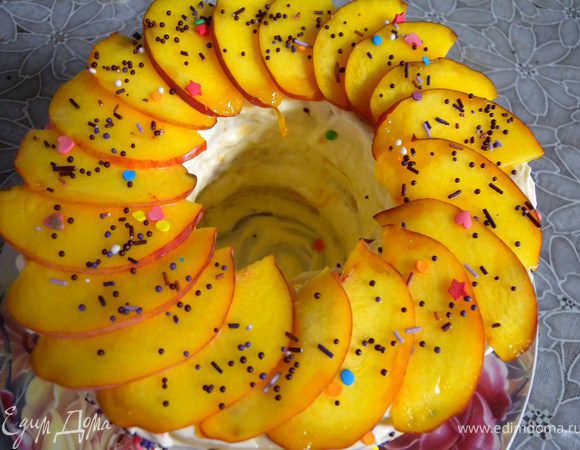 12. Немного остатков крема намазать наверх и украсить тонко порезанными дольками персика (2 шт).  Перед самой подачей посыпать присыпкой. Если раньше - она может полинять и потечь. 