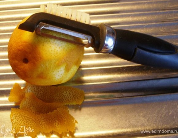 Овощечисткой аккуратно с апельсина снять цедру.