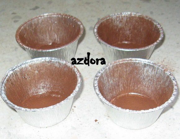 Приготовить алюминевые формочки для выпечки. Смазать их маслом и присыпать порошком какао, а не мукой. Если присыпать мукой, пирожные получатся белёсыми и некрасивыми.