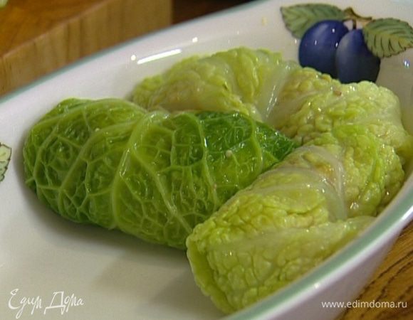 Уложить голубцы в керамическую форму как можно плотнее друг к другу, залить подогретым овощным бульоном на половину глубины формы, затянуть сверху фольгой и отправить в разогретую духовку на 20 минут. Затем снять фольгу и запекать еще несколько минут.