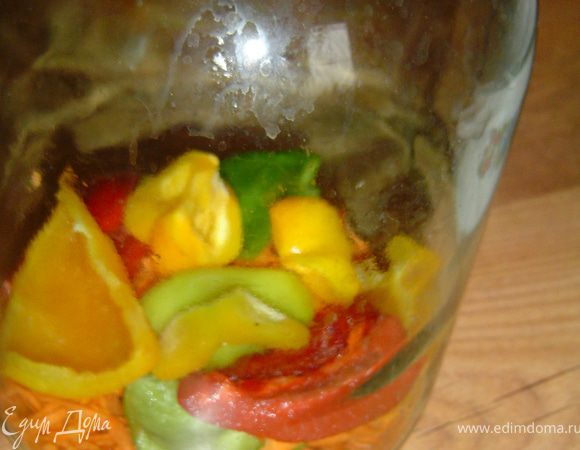 Подготовленные овощи выложите на дно банки, а сверху — помидоры. Все это залейте кипятком, накройте крышкой и дайте постоять 20 минут.