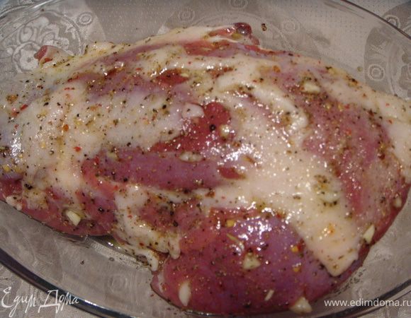 Сделать глубокие надрезы и нашпиговать  порезанными дольками чеснока. Посолить и поперчить.  Немного растереть.  Уложить в жаропрочную форму и обмазать оливковым маслом.  Закрыть крышкой или пищевой пленкой и оставить на 30-60 мин.